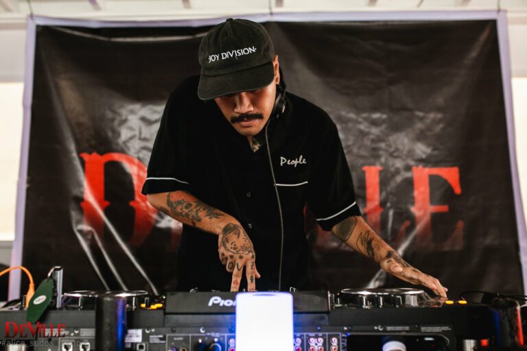 A DJ on a party boat playing on a DJ mixer