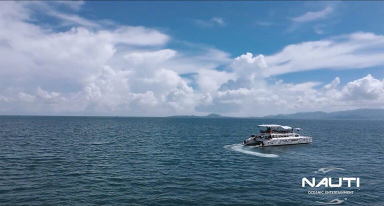 Nautibeat party boat in the sea with a company logo on the bottom right